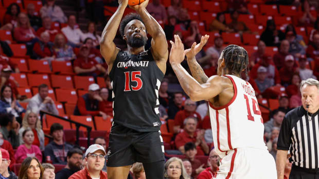 Mar 5, 2024; Norman, Oklahoma, USA; Cincinnati Bearcats forward John Newman III (15) shoots as Oklahoma Sooners forward Jalon Moore (14) defends during the first half at Lloyd Noble Center. Mandatory Credit: Alonzo Adams-USA TODAY Sports